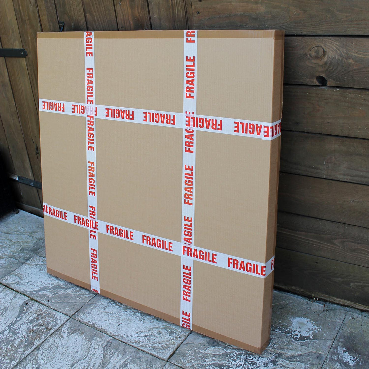 Stacked cardboard shipping boxes with "Fragile" warning labels on a rustic wooden background.