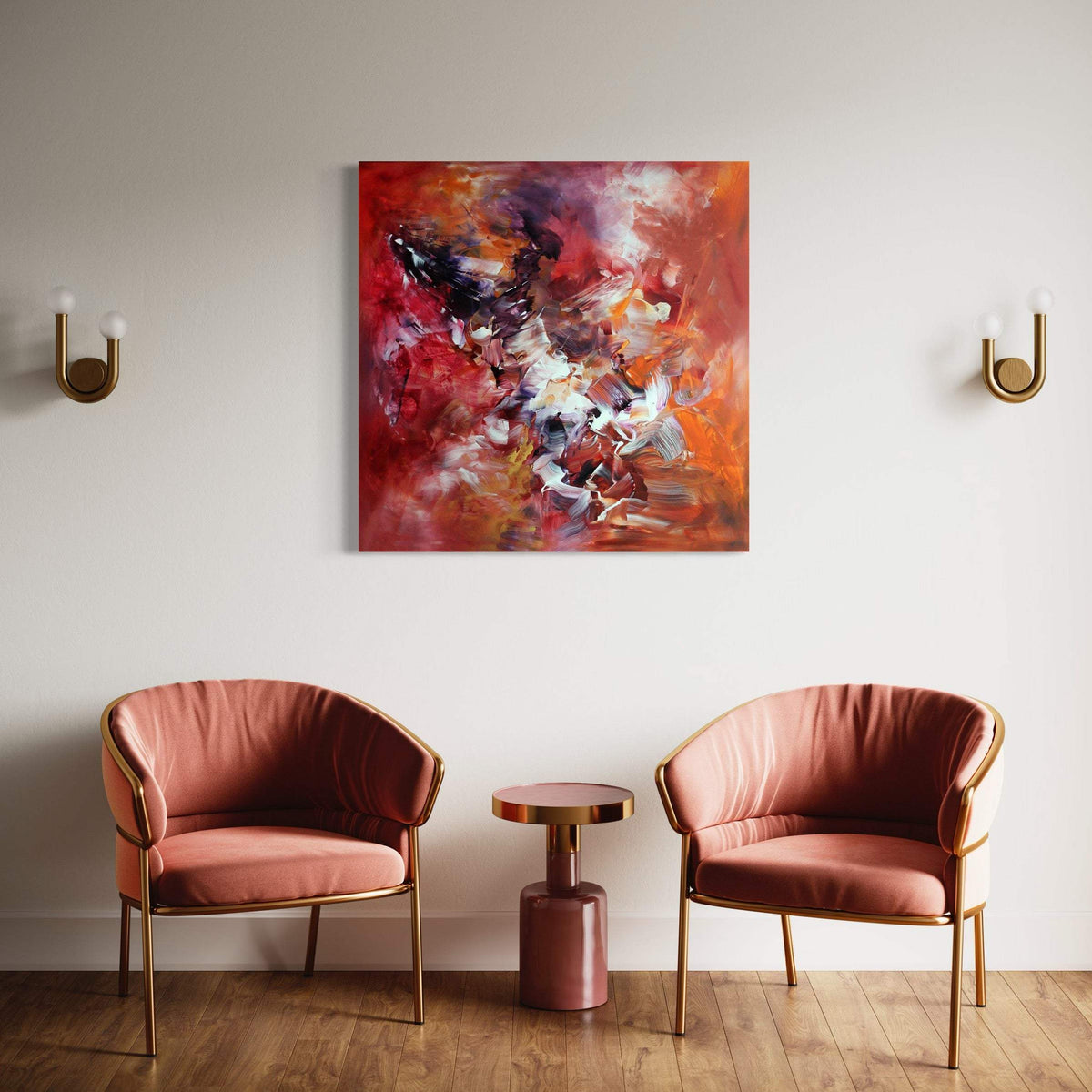 Vibrant abstract canvas art with bold colors and dynamic brushstrokes, displayed on a white wall above velvet armchairs in a modern, cozy room setting.