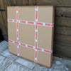 Large fragile cardboard boxes stacked against a wooden wall