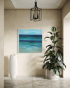 Serene coastal abstract art: Vibrant blue and green seascape painting in modern entryway with plant decor.