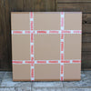 modern canvas painting packaged into Large cardboard box with 'Fragile' tape on a wooden background
