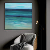 Serene abstract seascape artwork | Vibrant blue and green hues in framed painting | Cozy armchair with checkered pattern under spotlight