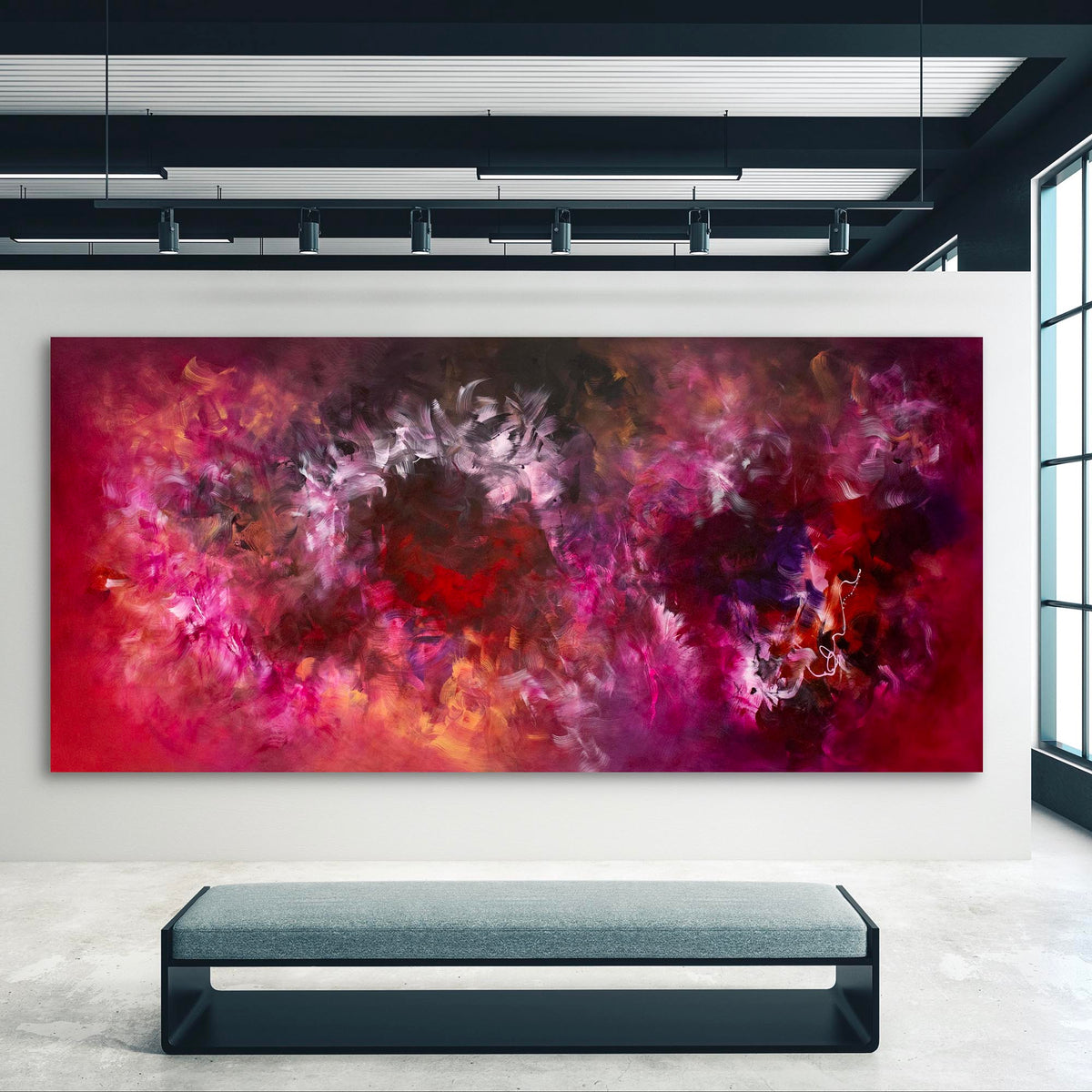 Large abstract art canvas with vibrant red, pink, and purple tones depicting a dynamic, expressive landscape. The artwork creates a bold, eye-catching focal point in the modern, minimalist interior setting.