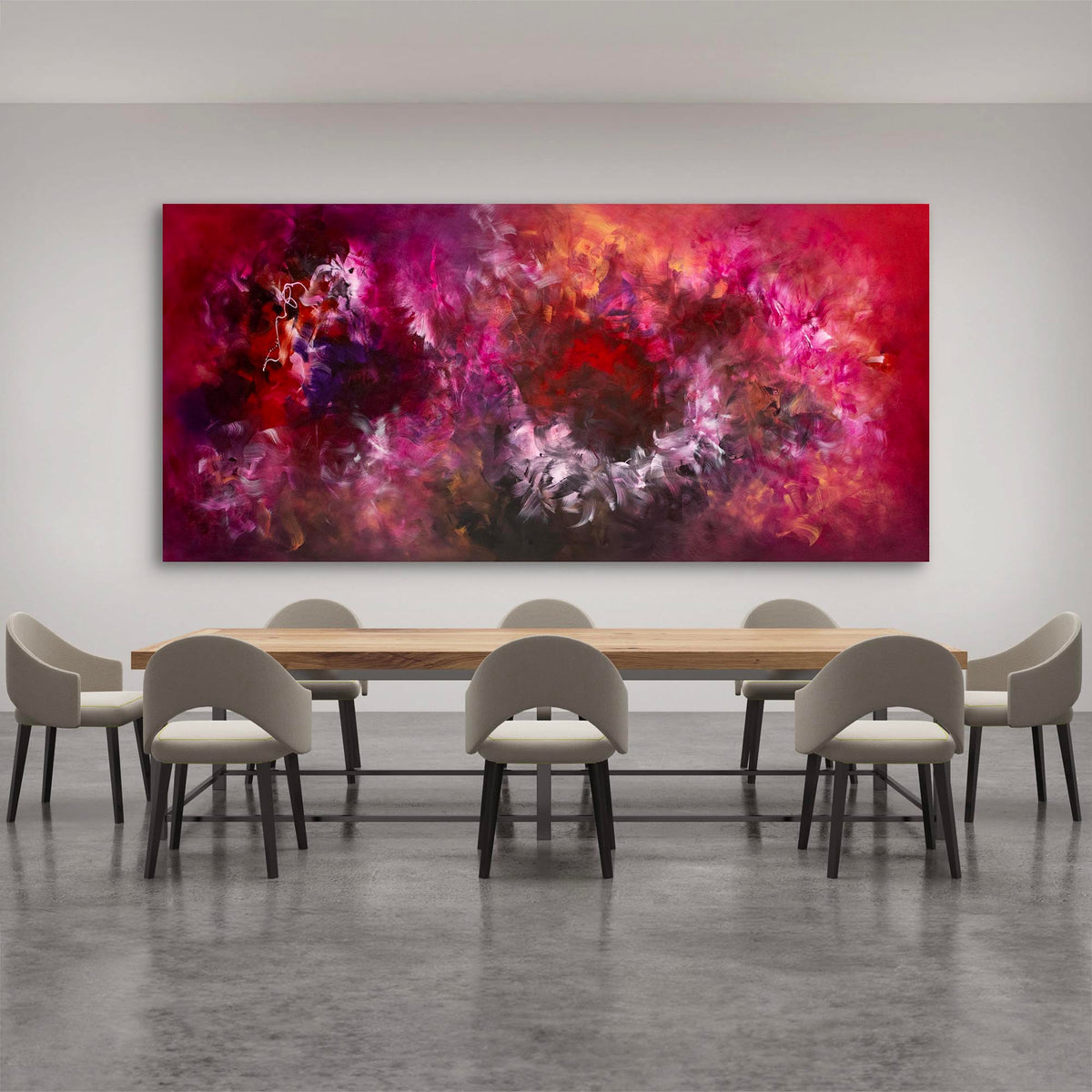 Vibrant abstract landscape art canvas depicting bold, colorful brushstrokes in shades of red, purple, and orange, displayed in a modern dining room setting with a wooden table and grey chairs.
