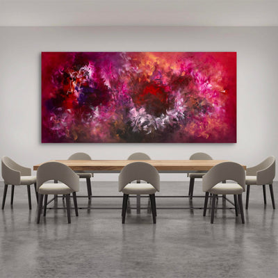 Vibrant abstract landscape art canvas depicting bold, colorful brushstrokes in shades of red, purple, and orange, displayed in a modern dining room setting with a wooden table and grey chairs.