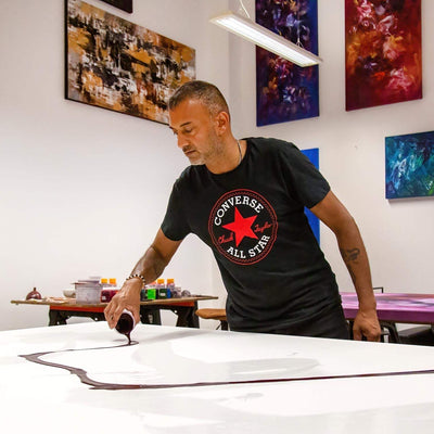 Paresh Nrshinga working on a colourful abstract canvas in his studio