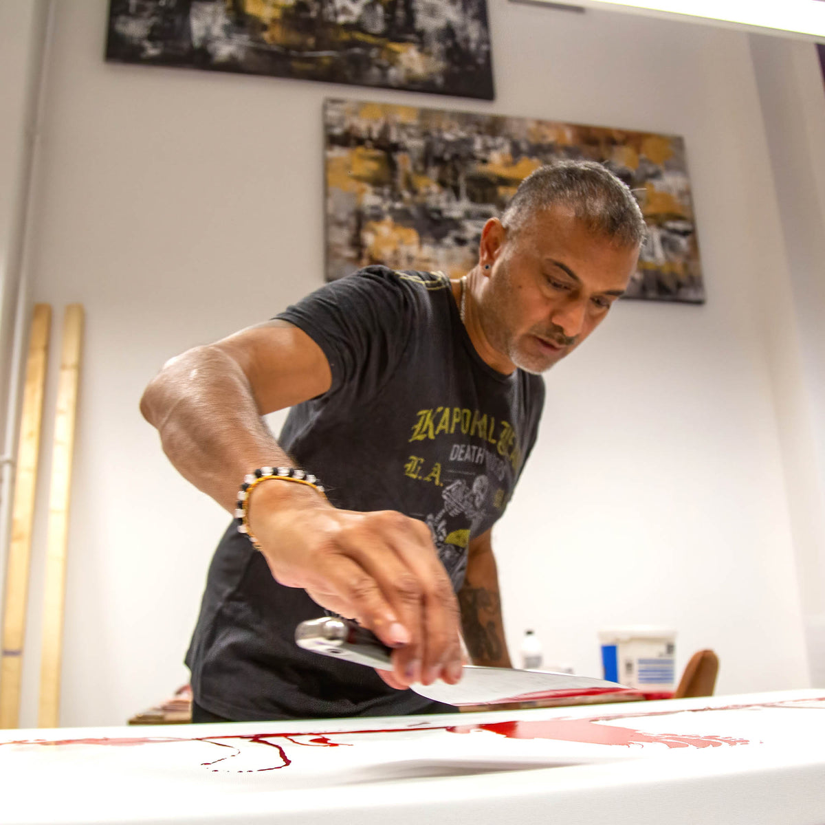 Abstract artist painting a large colorful abstract canvas in his studio