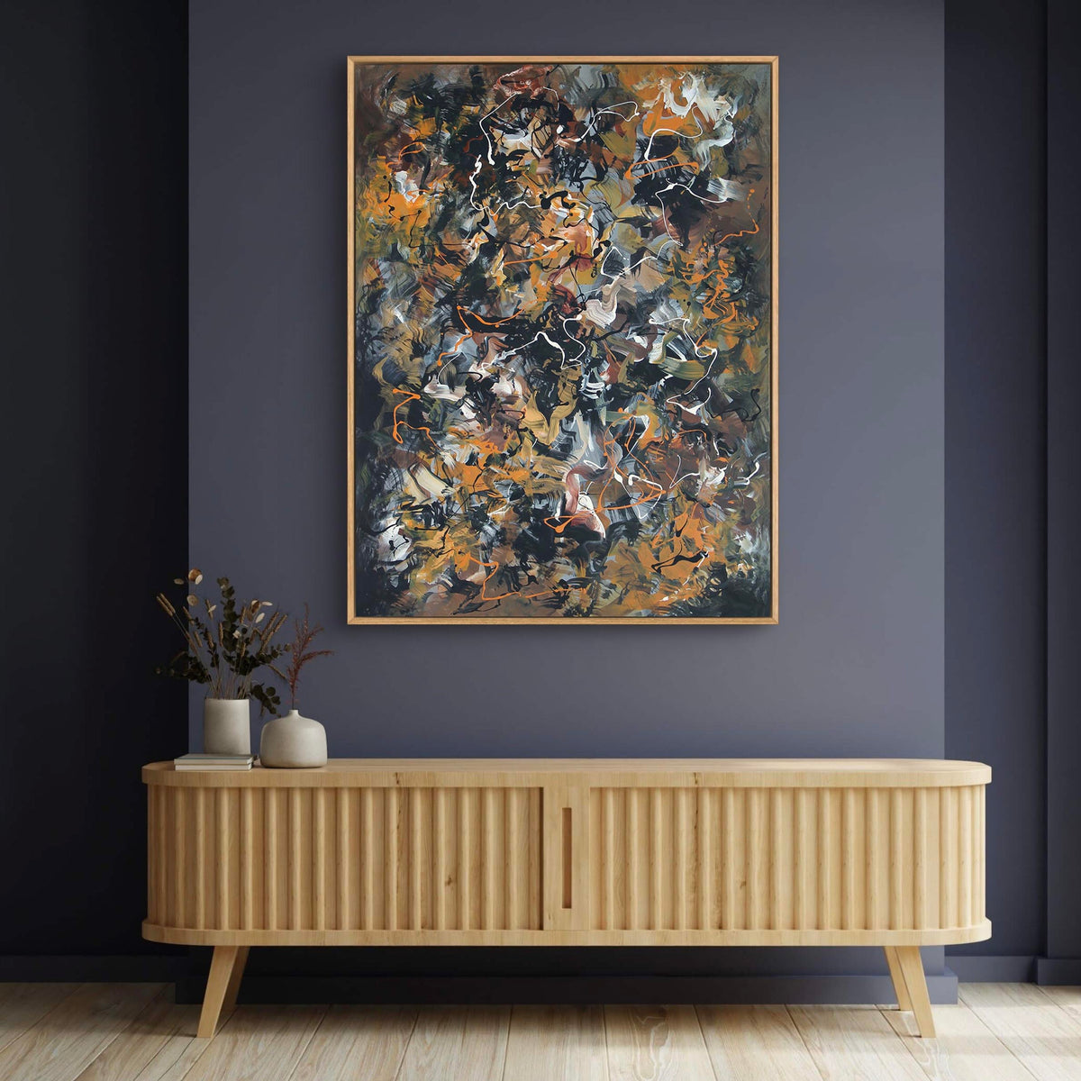 Vibrant abstract canvas art with earthy hues and textured brushstrokes, mounted on a dark gray wall above a wooden sideboard, creating a modern and artistic home decor setting.